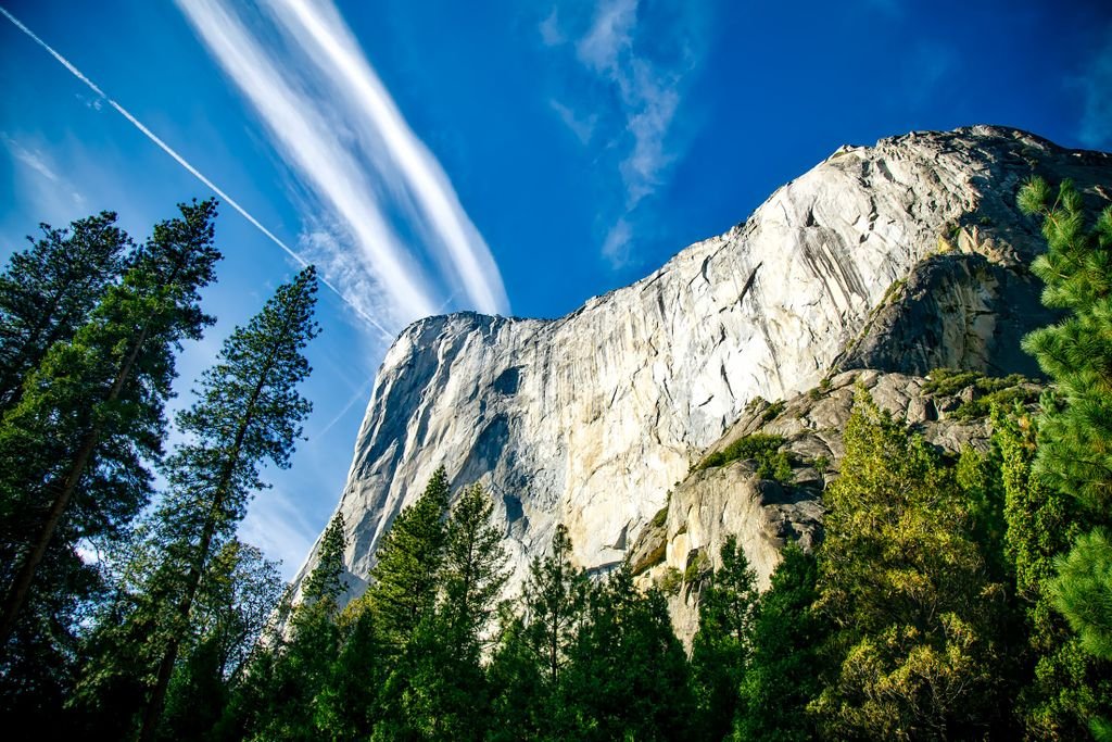 Majestic view of El Capitan's towering granite cliffs under a clear blue sky.