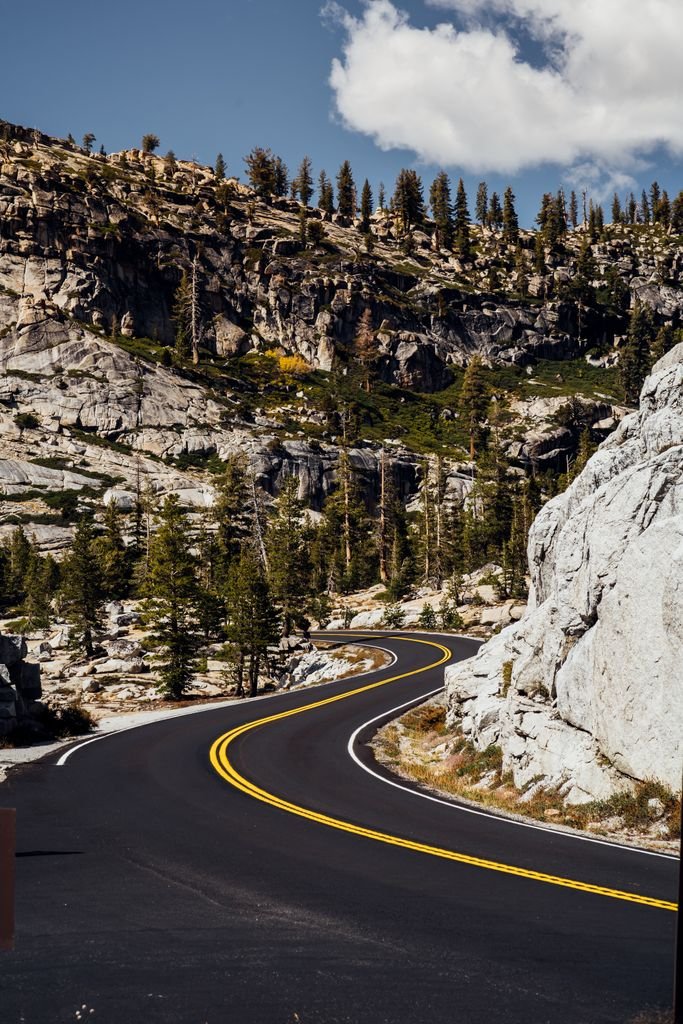 Winding road through a rocky mountain landscape under a clear sky, ideal for travel and nature themes.