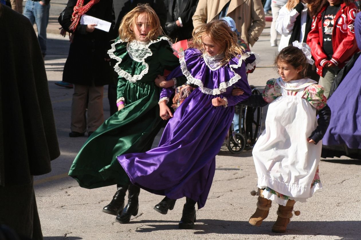 Girls in Victorian dresses dancing at Dickens on the Strand in Galveston